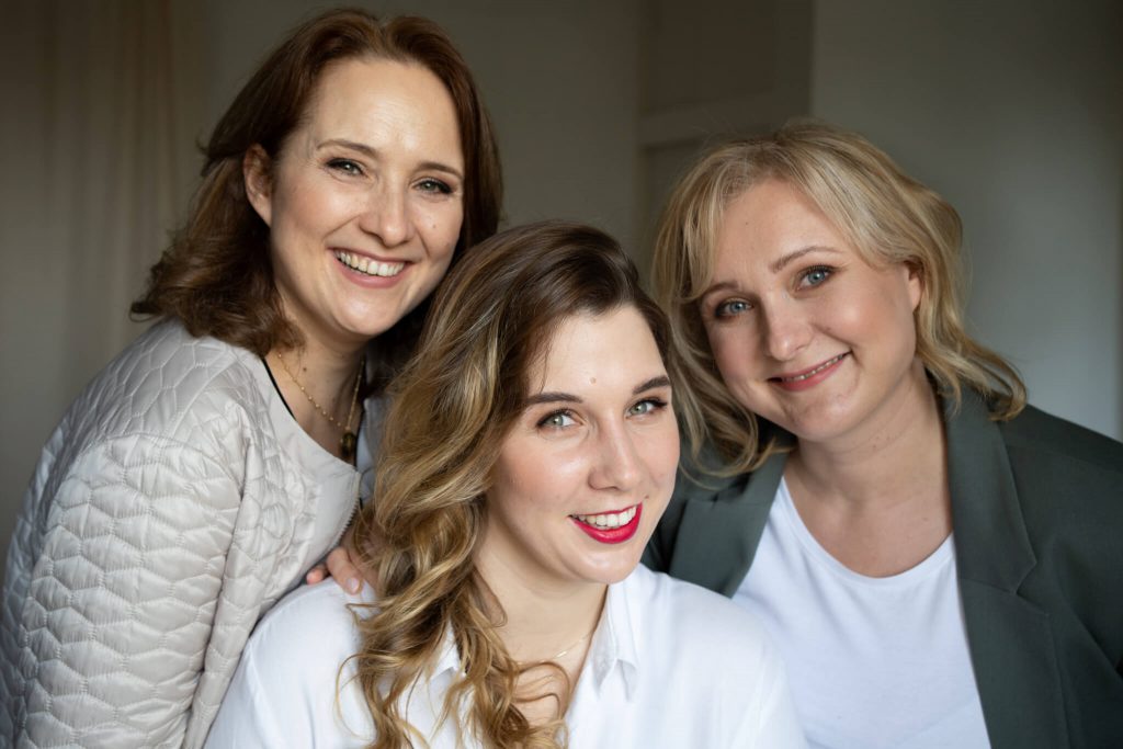 trzy kobiety uśmiechają się w stronę obiektywu